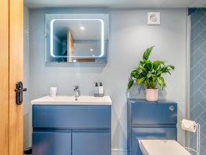 a bathroom with a blue sink and a mirror at 1 Bed in Gloucester oc-95793 in Tirley +15 photos