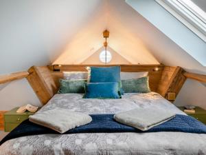 a bedroom with a bed with blue pillows at 1 Bed in Gloucester oc-95793 in Tirley