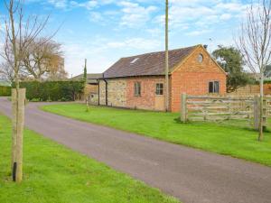 a brick house with a fence next to a road at 1 Bed in Gloucester oc-95793 in Tirley
