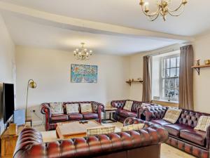 a living room with leather furniture and a chandelier at 6 Bed in Buxton oc-77369 in Longnor