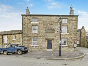 a blue truck parked in front of a brick building at 6 Bed in Buxton oc-77369 in Longnor