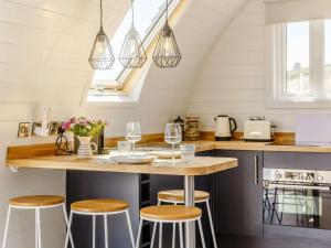 a kitchen with a counter with stools and a table at 1 Bed in Tain oc-81337 in Nigg +12 photos