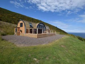 a cabin on a hill with the ocean in the background at 1 Bed in Tain oc-81337 in Nigg
