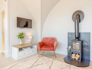 a living room with a chair and a wood stove at 1 Bed in Tain oc-81338 in Nigg +10 photos