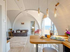 a living room with a table and a living room with the ocean at 1 Bed in Tain oc-81338 in Nigg