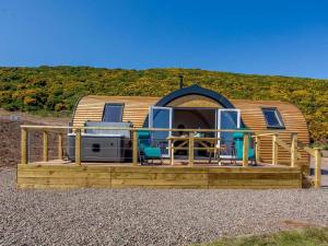 a cabin with a deck with chairs and a house at 1 Bed in Tain oc-81338 in Nigg