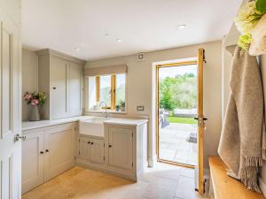 a kitchen with a sink and a door to a patio at 4 Bed in Wrexham oc-87675 in Chirk +38 photos
