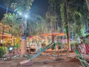 a playground with a slide in a park at night at Orchid Resort in Lataguri