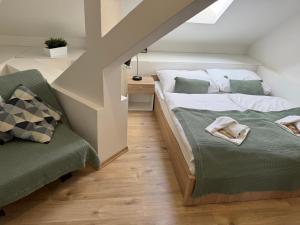 a attic bedroom with a bed and a chair at Pribina Penzión in Nitra
