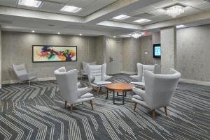 a waiting room with white chairs and a table at DoubleTree by Hilton Edmonton Downtown in Edmonton +32 photos