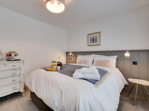 a bedroom with a large white bed and a table at 2 Bed in Anstruther oc-66733 in Pittenweem