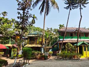 a house with palm trees in front of it at Orchid Resort in Lataguri