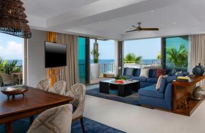a living room with a blue couch and a table at Conrad Punta de Mita in Punta Mita