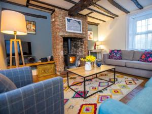 a living room with a couch and a table and a fireplace at 3 Bed in Kings Lynn oc-43950 in Docking