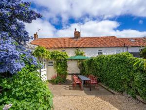 a house with a table and chairs and a hedge at 3 Bed in Kings Lynn oc-43950 in Docking