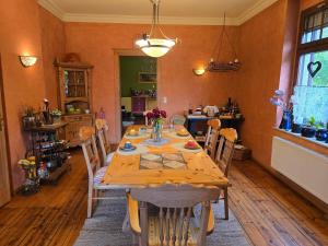 a dining room with a wooden table with chairs at Pension Max in Senftenberg