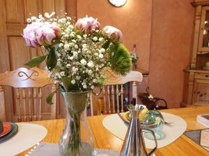 a vase filled with pink flowers on a table at Pension Max in Senftenberg