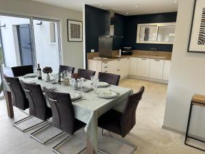 a dining room with a table and chairs and a kitchen at Gîte Le 10 in Neuville-du-Poitou
