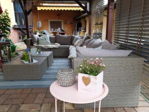 a patio with a couch and a table with flowers at Pension Max in Senftenberg