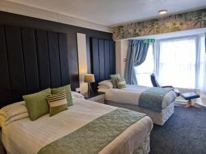 a hotel room with two beds and a window at Hen Dy in Llandudno