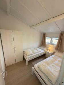 a bedroom with two beds and a window at Dune Nest 233 - beautiful house near beach - up to 4 guests with garden, parking, WLAN in Bredene