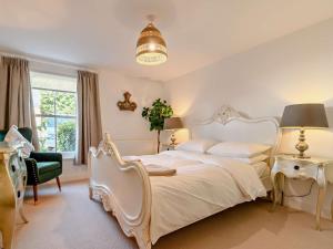 a bedroom with a large white bed and a chair at 1 Bed in Cirencester oc-90128 in Cirencester