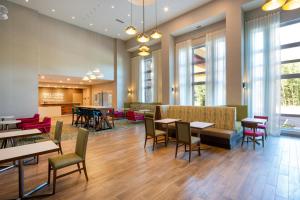 a waiting room with tables and chairs and windows at Hampton Inn & Suites Edmonton St. Albert, Ab in Edmonton