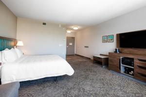 a hotel room with a bed and a flat screen tv at Hampton Inn & Suites Edmonton St. Albert, Ab in Edmonton