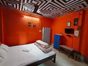 a bedroom with a bed with an orange wall at Orchid Resort in Lataguri +8 photos