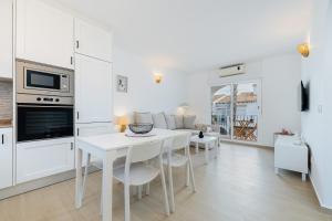 a kitchen and living room with a white table and chairs at Lago Jardin 69 in Los Altos