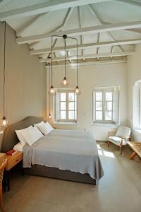 a bedroom with a large bed and two windows at Earino apartments in Hydra