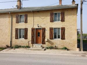 a brick house with a brown door on the side of it at CHAMBRE PRIVÉE à LA FERME in Authe