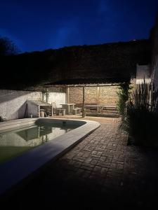 a swimming pool in a backyard with a table and a bench at BichoNegro Hostel in Concordia