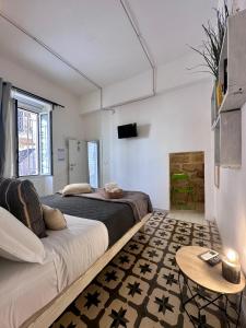a bedroom with two beds and a table in it at Nap25guesthouse in Polignano a Mare