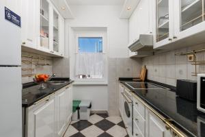 a kitchen with white cabinets and black counter tops at Apartment Audrey - free parking by Irundo in Rijeka