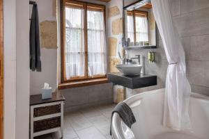 a bathroom with a tub and a sink at Hôtel La Maison du Prussien in Neuchâtel