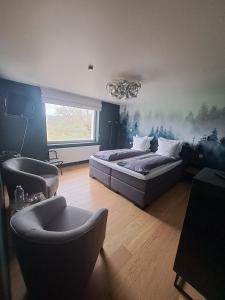 a bedroom with a bed and a couch and a chair at La Roseraie in Stavelot
