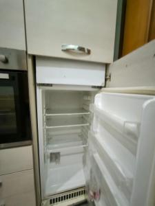 an empty refrigerator with its door open in a kitchen at Chalet di città in Rome