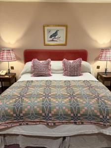 a bedroom with a large bed with two lamps at The Arundell in Lifton