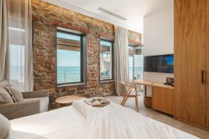 a bedroom with a brick wall and a bed and a desk at Porto Plomari in Plomari
