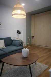 a living room with a blue couch and a table at Cozy Apartment Mazeikiai in Mažeikiai +1 photo