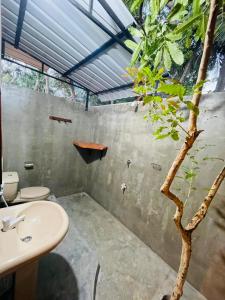 a bathroom with a sink and a tree in it at OM Inn in Trincomalee +50 photos