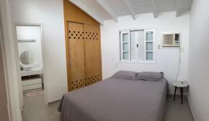 a small bedroom with a bed and a mirror at Flat Duplex Premium - Maresias - 150m da Praia Piscina, Wi-Fi e Garagem in São Sebastião +28 photos