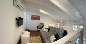 a living room with a couch and a tv at Flat Duplex Premium - Maresias - 150m da Praia Piscina, Wi-Fi e Garagem in São Sebastião
