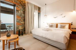 a bedroom with a large bed and a brick wall at Porto Plomari in Plomari +21 photos