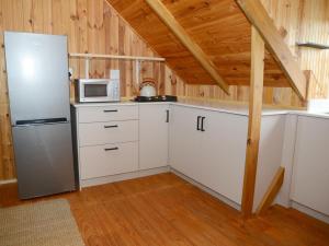 a kitchen with white cabinets and a refrigerator at Farside Macadamias in Riversdale +20 photos