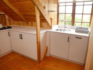 a kitchen with white cabinets and a sink at Farside Macadamias in Riversdale
