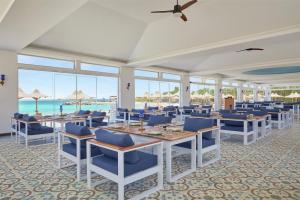 a dining room with tables and chairs and the ocean at Hilton Hurghada Plaza Hotel in Hurghada