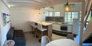 a kitchen with a couch and a table in a room at Flat Duplex Premium - Maresias - 150m da Praia Piscina, Wi-Fi e Garagem in São Sebastião