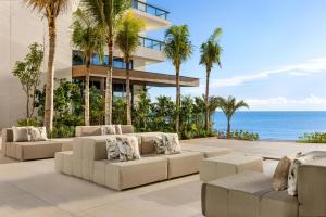 a patio with couches and the ocean in front of a building at Hilton Cancun, an All-Inclusive Resort in Cancún